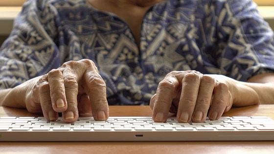 Bild på en äldre person vid dator