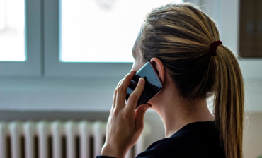 Bild på anonym kvinna som talar i telefon.