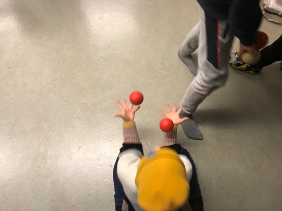 Elev jonglerar med två röda bollar