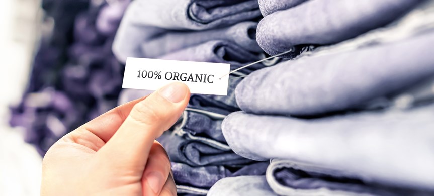 Dekorbild på en hög med jeans och en lapp där det står 100 % organic.